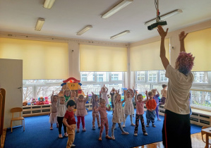 Grupa śpiewa z rękami podniesionymi do góry