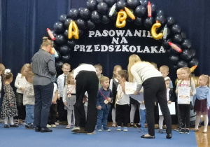 Pani dyrektor wręcza pasowanym dzieciom medale