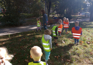 dzieci w parku zbierają kasztany