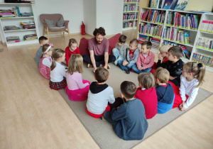 dzieci słuchają bajki czytanej przez pana z biblioteki