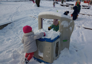 Dziewczynki grabią śnieg znajdujący się na urządzeniach.