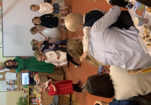 Dzieci stoją na dywanie i śpiewają wyuczoną wcześniej piosenkę.