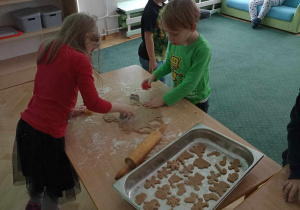 Chłopiec i dziewczynka wykrawają ciasteczka.