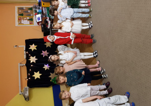Dzieci stoją w półkolu i śpiewają świąteczną piosenkę.