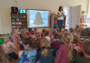 Nauczycielka prezentuje dzieciom ilustrację.