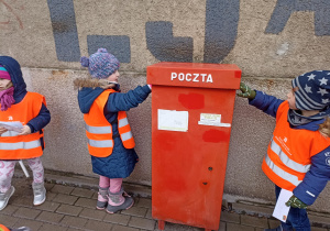 Dzieci wrzucają swoje listy do skrzynki pocztowej.