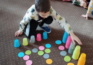 Chłopiec podjął próbę ułożenia kubków według wzoru.