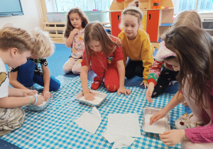 Dzieci bawią się sztucznym śniegiem