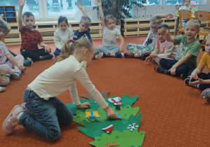 Dziewczynka ozdabia choinkę.