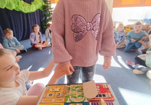 Dziewczynka stoi przed kolorową zabawką